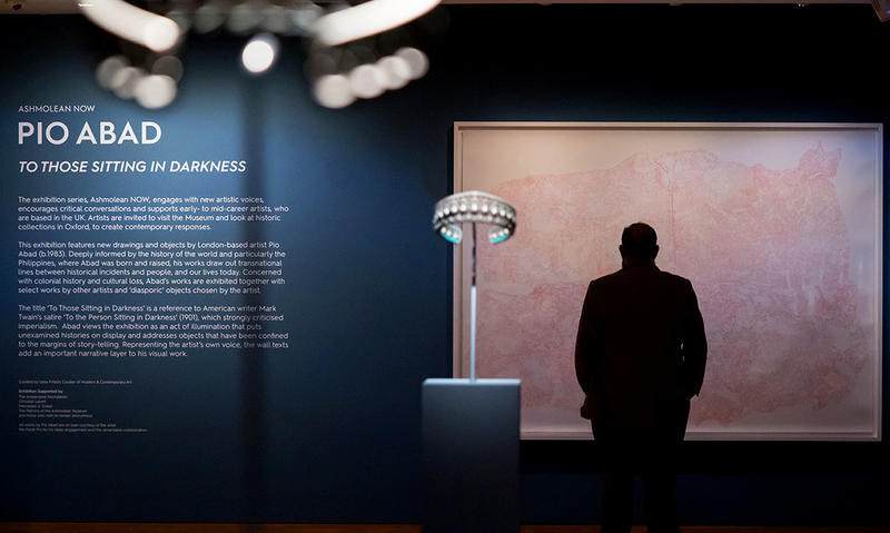 Inside the Pio Abad exhibition showing the sign and the visitor looking at the Powhatan's Mantle drawing