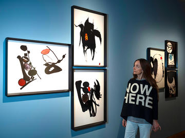 Bettina von Zwehl in Gallery 8 setting up her Ashmolean Now exhibition, The Flood, looking at her Thing series photographs against the blue wall of the gallery